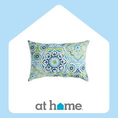 a blue and green pillow with the words at home on it