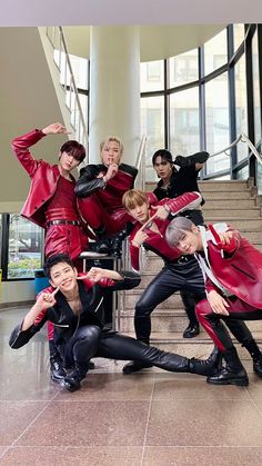 a group of people in red and black outfits posing for a photo on some stairs