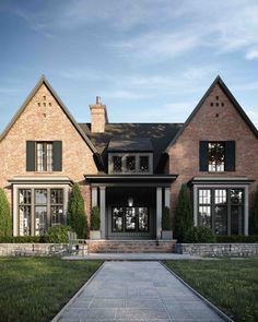 a large brick house with black shutters on the front and side windows, along with a stone walkway leading up to it