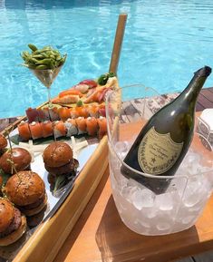 a table with food and drinks near a swimming pool