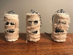 three rolls of twine wrapped in burlap with faces on them and eyes drawn on the sides