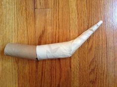 a piece of toilet paper wrapped in white tape on a wooden table with wood grained flooring