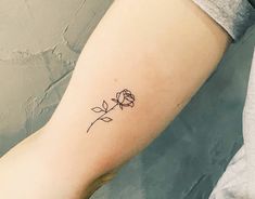 a small rose tattoo on the arm