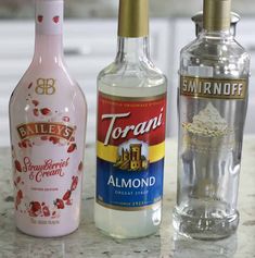 three different types of alcohol sitting on a counter next to each other, one is empty and the other contains ice cream