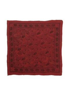 a red square rug with an intricate design on the front and side, against a white background