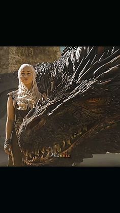 a woman standing next to a giant dragon