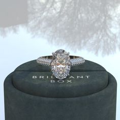 a diamond ring sitting on top of a box with a reflection in the water behind it