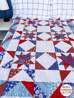 a red, white and blue quilt on a bed