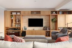 a living room filled with furniture and a flat screen tv mounted on a wall above a fireplace