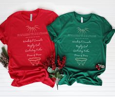 two christmas t - shirts sitting next to each other on top of a white table