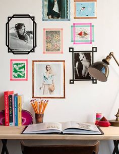 an open book sitting on top of a desk next to pictures and bookshelves