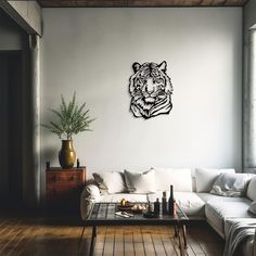 a living room with white couches and a tiger wall decal