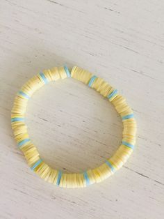 a yellow and blue bracelet sitting on top of a wooden table