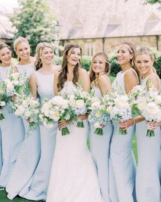 a group of women standing next to each other holding bouquets