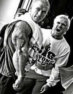 an older man and young woman posing for the camera with their arms spread wide open