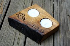 two candles are sitting on top of a wooden block