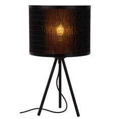 a black lamp with a brown shade on it's side and a wooden base