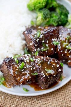 some meat and rice on a plate with broccoli