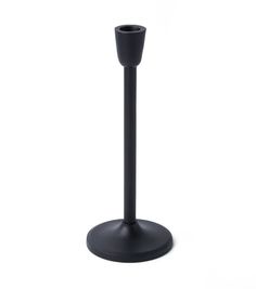 a tall black candle holder on a white background with no one around it to see the light