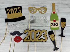 new year's eve photo booth props with champagne and hats on wooden sticks, ready to be used as decorations