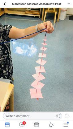 a woman is making pink paper arrows on the floor