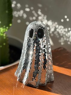 a glass figurine that has been made to look like a ghost with black eyes