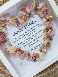 a frame with flowers in the shape of a heart that reads, cracias mama