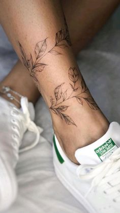 a close up of a person's foot with a flower tattoo on the ankle