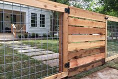 a fenced in area with wooden boards and metal bars on the sides, along with grass