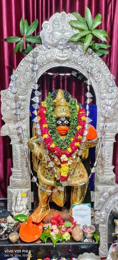 an idol is displayed in the middle of a stage with flowers and decorations around it