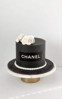 a black and white chanel cake with flowers on top