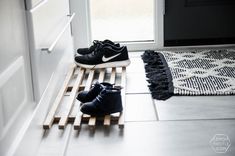 two pairs of shoes sitting on top of a wooden bench in front of a door