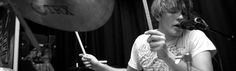 a young man playing drums in front of microphones