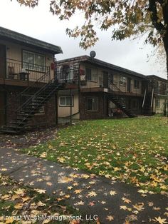 an apartment complex with stairs leading up to the second floor and another building in the background