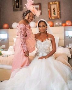 two women in wedding dresses posing for the camera