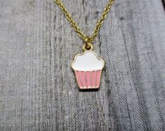 Cute cupcake necklace, with matching brass chain and closes with a lobster claw clasp. Pendant is 16mm long, 11mm wide Choose your length of chain during checkout. I package each piece of jewelry in a colorful organza bag. Perfect for gift giving or a gift for yourself. Don't forget to look through the add on section to add more customized fun. https://www.etsy.com/shop/RevelryJewelry Thank you fairy much. Cute Charm Necklaces For Gifts, Gold Novelty Charm Necklace For Gifts, Gold Novelty Charm Necklaces For Gifts, Sweet Silver Necklace Perfect For Gifts, Novelty Jewelry With Lobster Clasp For Gift, Sweet Nickel-free Jewelry For Gifts, Sweet Nickel-free Jewelry Gift, Nickel-free Novelty Charm Necklace For Gift, Novelty Necklace With Lobster Clasp For Gift