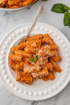 two plates filled with pasta covered in sauce and parmesan cheese