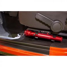 a red flashlight is sitting in the back seat of a car with its door open