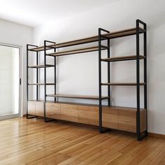 an empty room with wooden floors and shelving unit