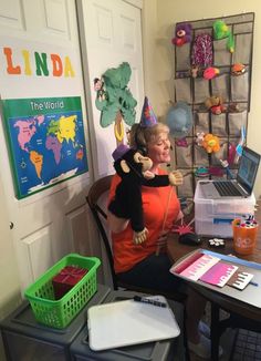 a woman sitting at a desk holding a stuffed animal