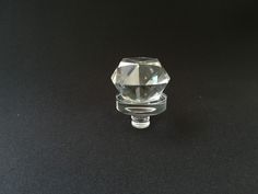 a clear glass knob on a black surface