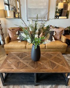 a living room filled with furniture and a large vase on top of a coffee table