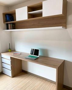 a laptop computer sitting on top of a wooden desk next to a book shelf with books