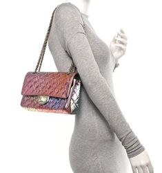 a mannequin wearing a grey dress and holding a multicolored handbag