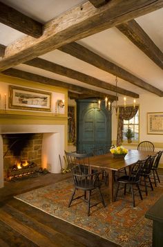 a dining room table and chairs in front of a fire place with an open fireplace