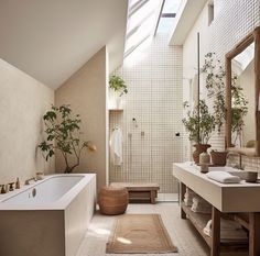 a large bathroom with a skylight above the bathtub and sink, along with a rug on the floor