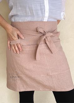 a woman is wearing an apron and has her hands on the waist with one hand