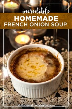 french onion soup in a white bowl with candles behind it