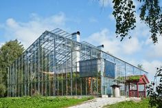 a glass house sitting on top of a lush green hillside