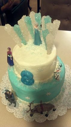 there is a cake with frosting on the top and frozen decorations on the bottom